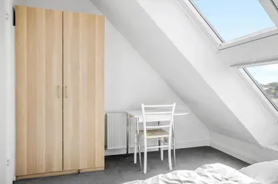 a bedroom with a table and a chair in a attic at 1340-Thisted-Nordsovej-104 in Thisted