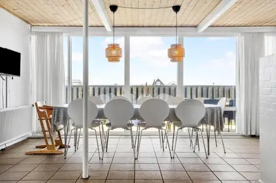 a dining room with a table and white chairs at 1340-Thisted-Nordsovej-104 in Thisted