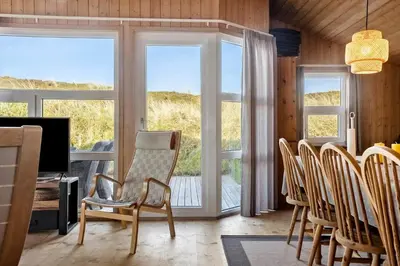 a living room with a table and chairs and a television at 1062-Thisted-Mombak-45 in Torsted