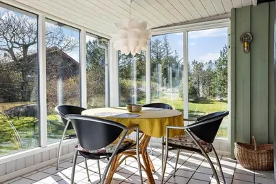 a dining room with a table and chairs and windows at 246-Thisted-Pighvarvej-16 in Thisted