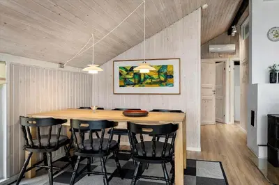 a kitchen with a wooden table and black chairs at 1342-Thisted-Mose-Bolle-Vej-8 in Thisted