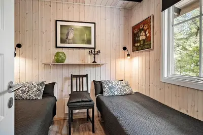 a bedroom with a bed and a chair and a window at 1344-Vestervig-Hedevej-43 in Vestervig