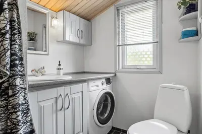 a bathroom with a washing machine and a sink at 1326-Thisted-Blabaervej-6 in Thisted