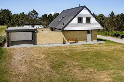 a house with a garage and a bench in a yard at 1348-Thisted-Klemsvej-14 in Thisted