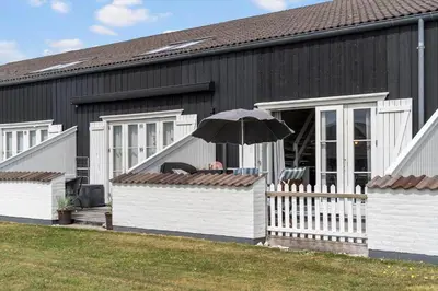 a black building with a white fence and an umbrella at 1346-Vestervig-Havnevej-1-lejl-15 in Vestervig