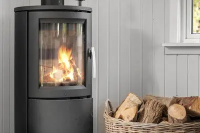 a fireplace in a room with a basket of logs at 1350-Thisted-Blabaervej-22 in Thisted