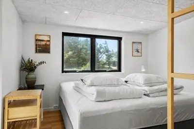 a bedroom with a bed with white sheets and a window at 1068-Thisted-Klovborgsti-5-A in Torsted