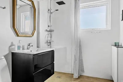 a bathroom with a sink and a shower and a mirror at 148-Thisted-Fiskervej-74 in Thisted