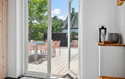 a sliding glass door leading to a patio with a table at 4 Bedroom Nice Home In Bedsted Thy in Bedsted Thy