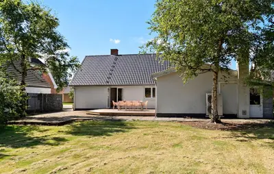 a white house with two chairs on a patio at 4 Bedroom Nice Home In Bedsted Thy in Bedsted Thy