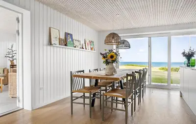 a dining room with a table and chairs and the ocean at 4 Bedroom Cozy Home In Fur in Fur