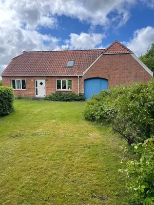 a red brick house with a blue garage at Cozy property in the countryside in beautiful nature in Vinderup