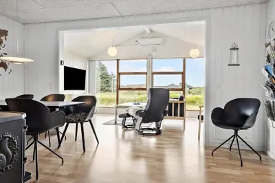 a dining room with black chairs and a table at 1351-Thisted-Mose-Bollevej-13 in Thisted