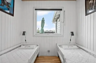 two beds in a white room with a window at 1351-Thisted-Mose-Bollevej-13 in Thisted