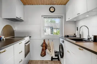 a kitchen with white cabinets and a clock on the wall at 1353-Snedsted-Ebenezervej-24 in Snedsted