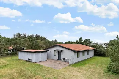a small white house with a porch in a field at 1352-Vestervig-Isfuglevej-19 in Vestervig