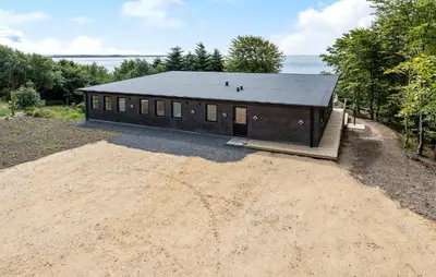 a large building with a black roof on a dirt field at Awesome Home In Spøttrup With Wifi in Spottrup