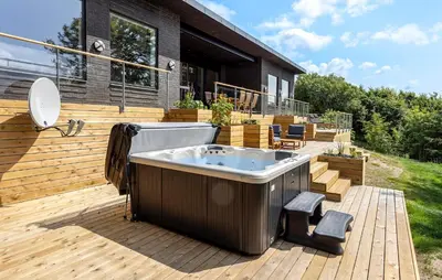 a hot tub on a deck next to a house at Awesome Home In Spøttrup With Wifi in Spottrup