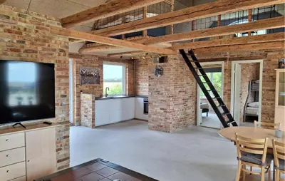 a living room with a brick wall and a television at 3 Bedroom Amazing Home In Erslev in Erslev