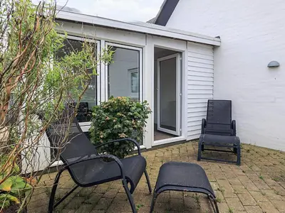 two black chairs sitting on a patio in front of a house at 6 person holiday home in Thisted in Thisted