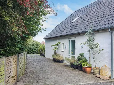 a white house with potted plants in front of it at 6 person holiday home in Thisted in Thisted