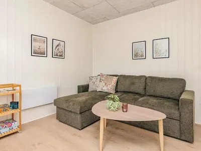 a living room with a couch and a table at 5 person holiday park home in Pandrup in Pandrup
