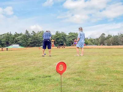 a couple of people playing frisbee in a field at 5 person holiday park home in Pandrup in Pandrup