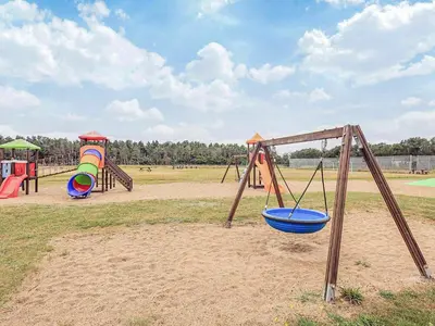 a playground with two play equipment in a field at 5 person holiday park home in Pandrup in Pandrup