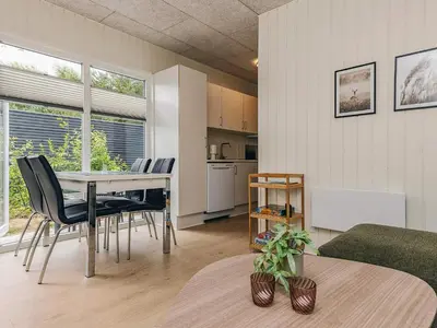 a living room with a table and chairs and a kitchen at 5 person holiday park home in Pandrup in Pandrup