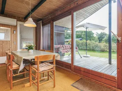 a dining room with a table and a deck at 8 person holiday home in Skals-By Traum in Skals