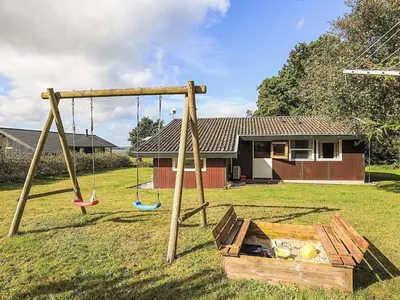 a swing set in a yard with a house at 8 person holiday home in Skals-By Traum in Skals
