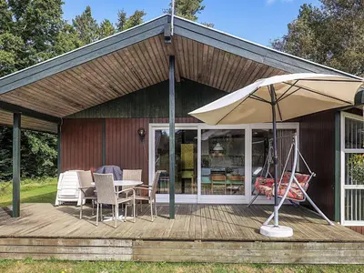 a patio with an umbrella and a table and chairs at 8 person holiday home in Skals-By Traum in Skals