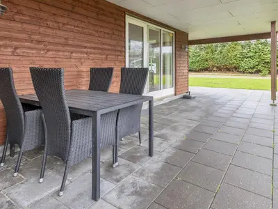 a wooden table and chairs on a patio at 4 star holiday home in Farsø-By Traum in Farsø