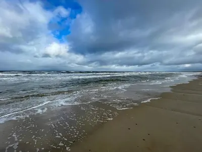 a beach with the ocean on a cloudy day at 12 person holiday home in Pandrup-By Traum in Pandrup