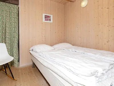 an unmade bed in a room with a window at 12 person holiday home in Pandrup-By Traum in Pandrup