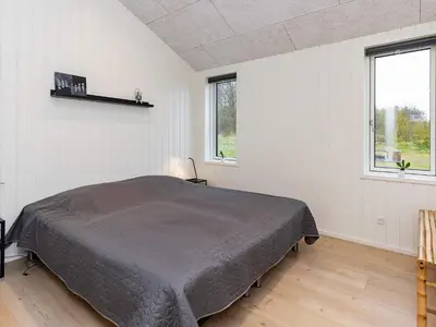 a bedroom with a bed in a room with windows at 8 person holiday home in Saltum-By Traum in Saltum
