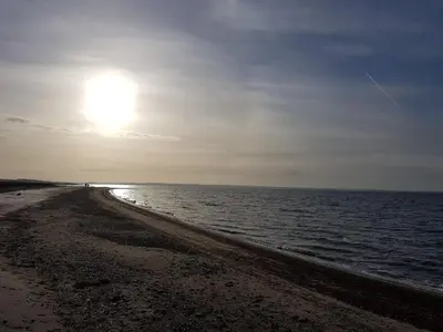 a beach with the sun rising over the water at 6 person holiday home in Vinderup-By Traum in Vinderup