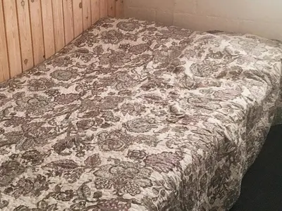 a bed with a flowered blanket on top of it at 6 person holiday home in Vinderup-By Traum in Vinderup