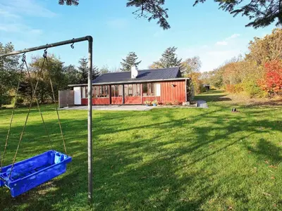 a yard with a swing in front of a house at 6 person holiday home in Vinderup-By Traum in Vinderup