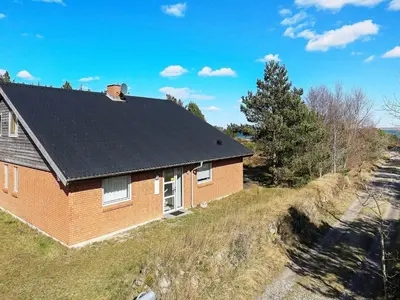 a red brick house with a black roof at 8 person holiday home in Thyholm-By Traum in Thyholm