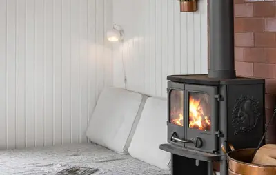a wood stove in a room with a couch at 4 Bedroom Beautiful Home In Thisted in Thisted
