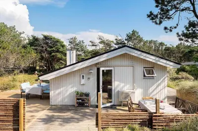 a small white shed with a patio and a table at 1333-Thisted-Sandtornvej-43 in Thisted