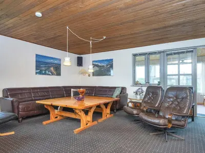 a living room with a couch and a table and chairs at 10 person holiday home in Harboøre-By Traum in Harboør