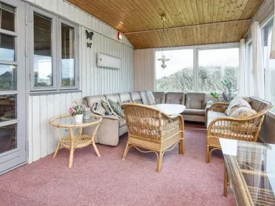 a porch with a couch and chairs and a table at 10 person holiday home in Harboøre-By Traum in Harboør