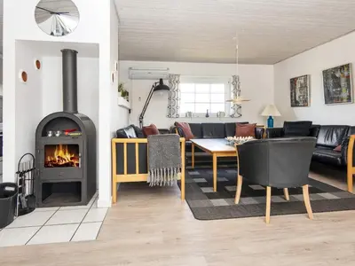 a living room with a couch and a fireplace at 12 person holiday home in Harboøre-By Traum in Harboør