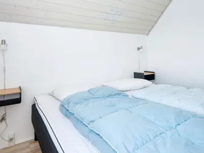 a bedroom with two beds with blue sheets at 12 person holiday home in Harboøre-By Traum in Harboør
