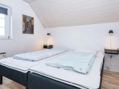 two beds in a room with two lamps on the wall at 12 person holiday home in Harboøre-By Traum in Harboør
