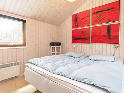a bed in a room with paintings on the wall at 8 person holiday home in Fjerritslev-By Traum in Fjerritslev