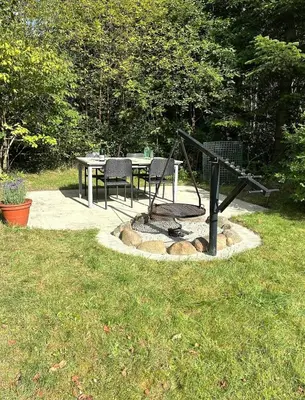 a patio with a table and chairs and a playground at Family Cabin By The Calm Waters Of Limfjord in Højslev