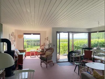 a room with tables and chairs and a room with windows at Holiday Home By Limfjord With Historic Charm in Farsø